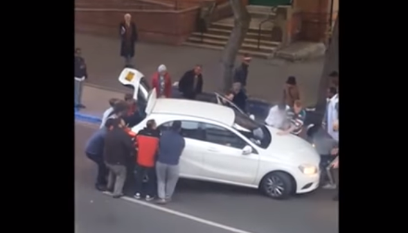 Shtatëvjeçari ngec poshtë veturës - 15 kalimtarë tentojnë shpëtimin (VIDEO)