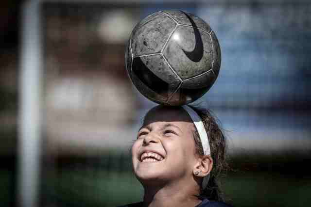 Vajza që luan futboll në një ekip me djemtë