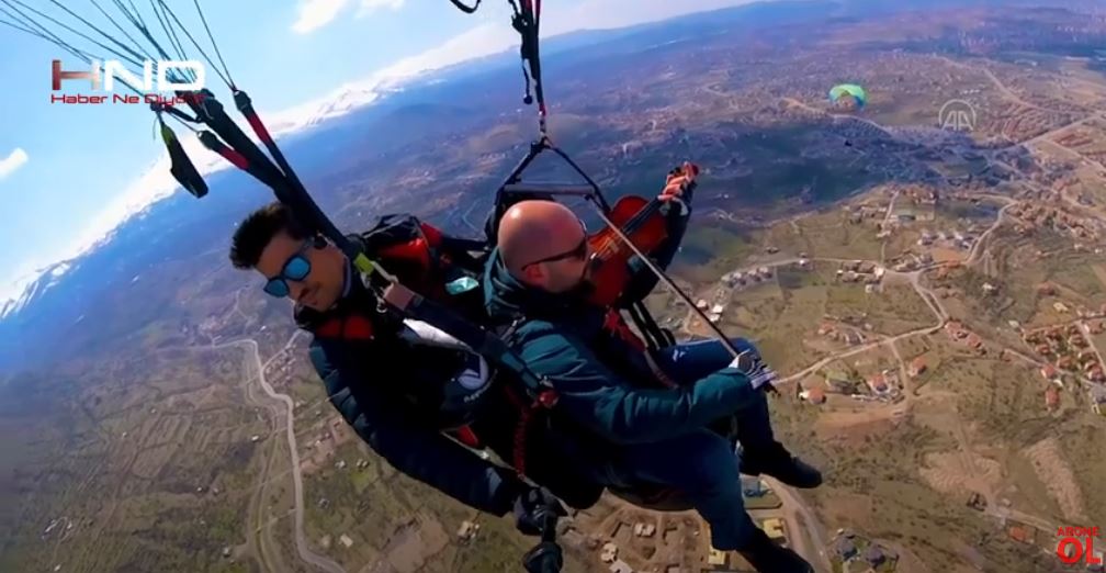 Muzikanti e tejkalon frikën e fluturimit me parashutë duke luajtur në violinë (VIDEO)