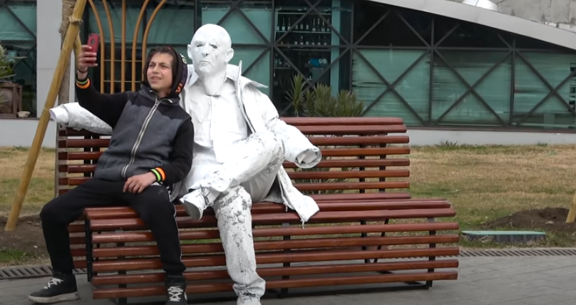 Reagimi i çuditshëm i të riut kur fotografohet me statujën prej njeriu! (VIDEO)