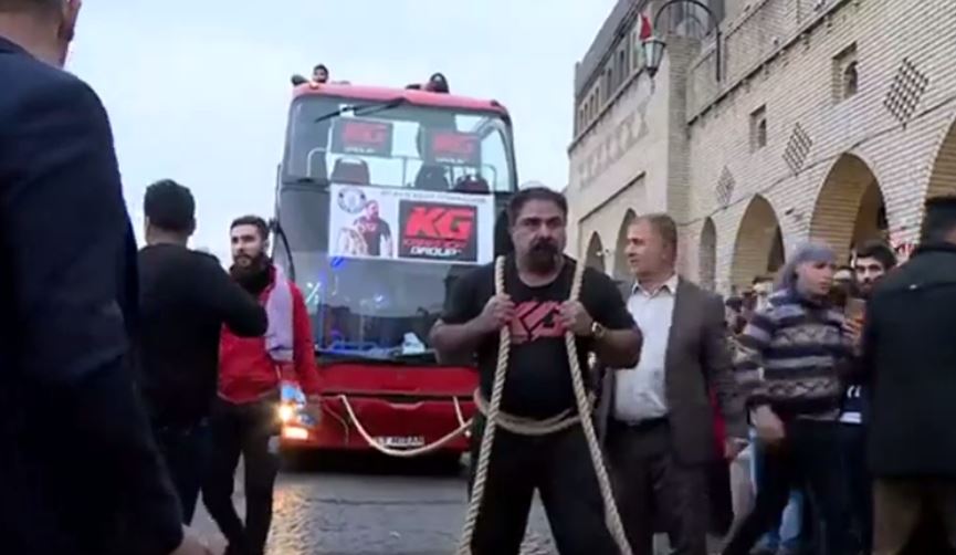 Njeriu i fortë tërheqë autobusin dykatësh në Irak (VIDEO)