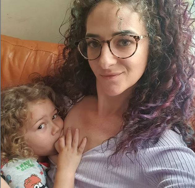 Gruaja që ushqen me gji dy fëmijët e saj, përfshirë djalin katërvjeçar