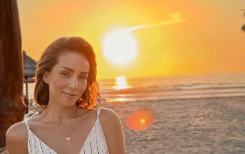 Miriam Cani shijon perëndimin e diellit, pranë detit